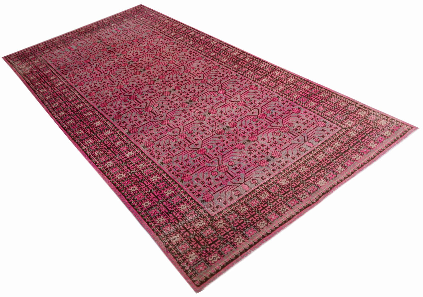 An antique handwoven Khotan rug featuring an intricate pomegranate pattern in vibrant pink tones.