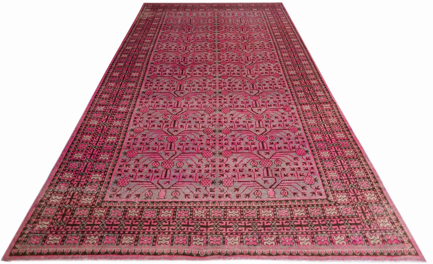 An antique handwoven Khotan rug featuring an intricate pink pomegranate pattern on a grey field.