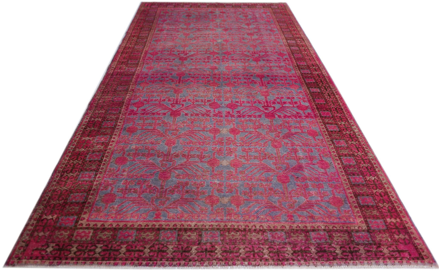An antique handwoven Chinese Khotan rug featuring an intricate pomegranate pattern in vibrant pink.
