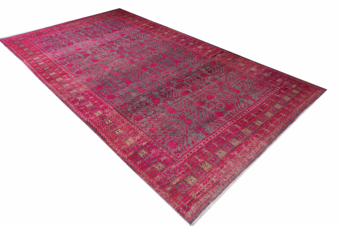 An antique Chinese Khotan rug featuring an intricate pomegranate pattern in vibrant pink and grey.
