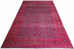 An antique handwoven Khotan rug featuring an intricate pomegranate pattern in vibrant pink and grey.