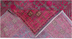 An antique handwoven Khotan rug featuring an intricate pomegranate pattern in vibrant pink.