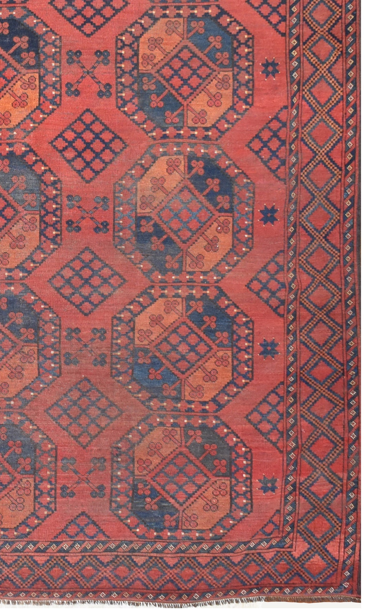 An antique Afghan Turkmen rug featuring a repeating red and blue elephant foot geometric pattern.