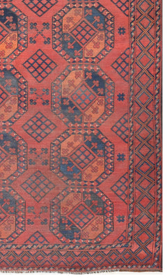 An antique Afghan Turkmen rug featuring a repeating red and blue elephant foot geometric pattern.