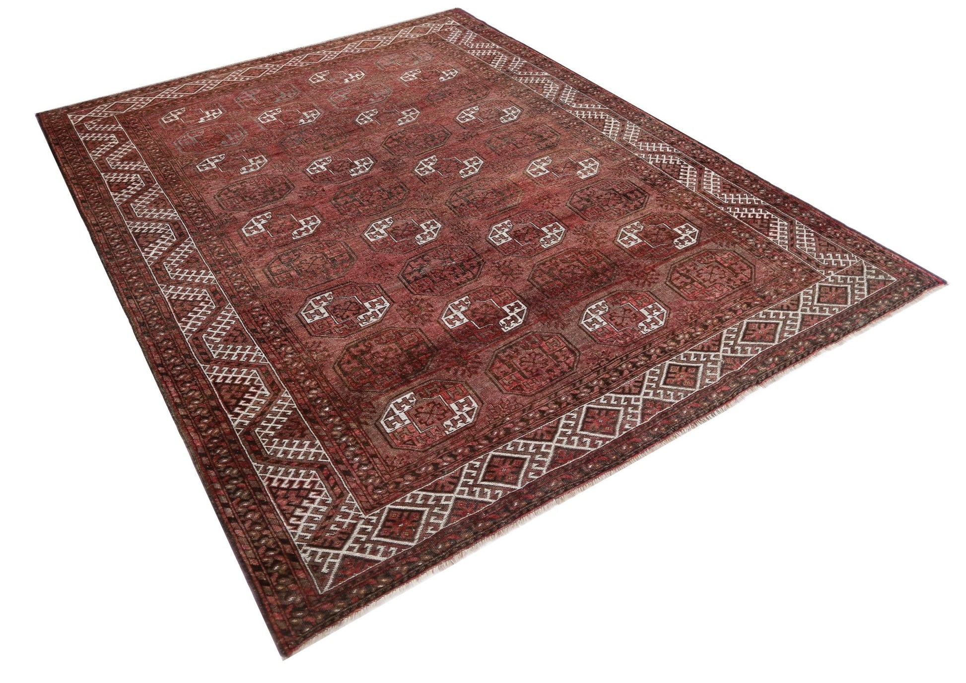 An antique Afghan Turkmen rug featuring traditional red tones and repeating elephant foot motifs.