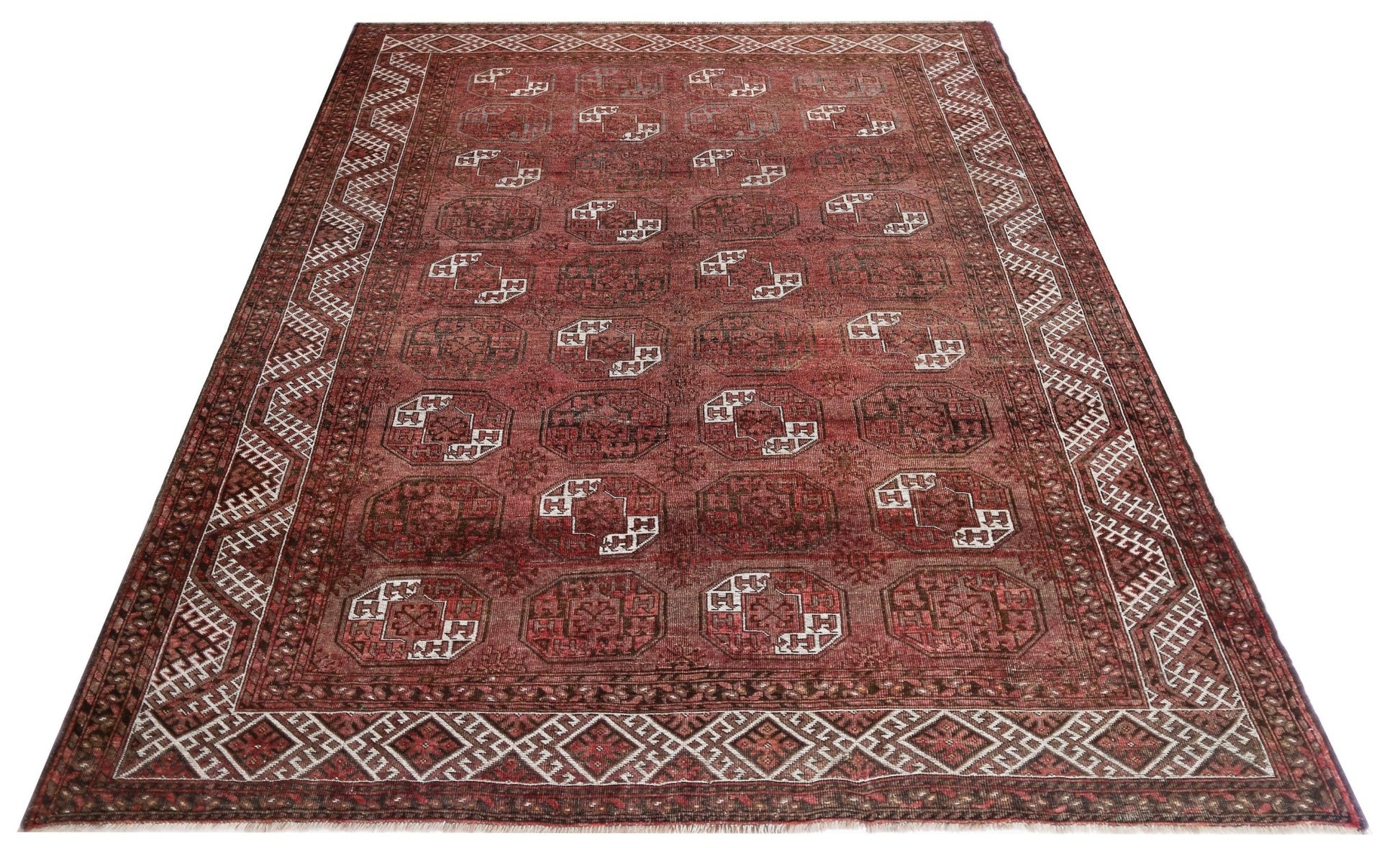 An antique Afghan Turkmen rug featuring repeating elephant foot motifs in deep red wool.