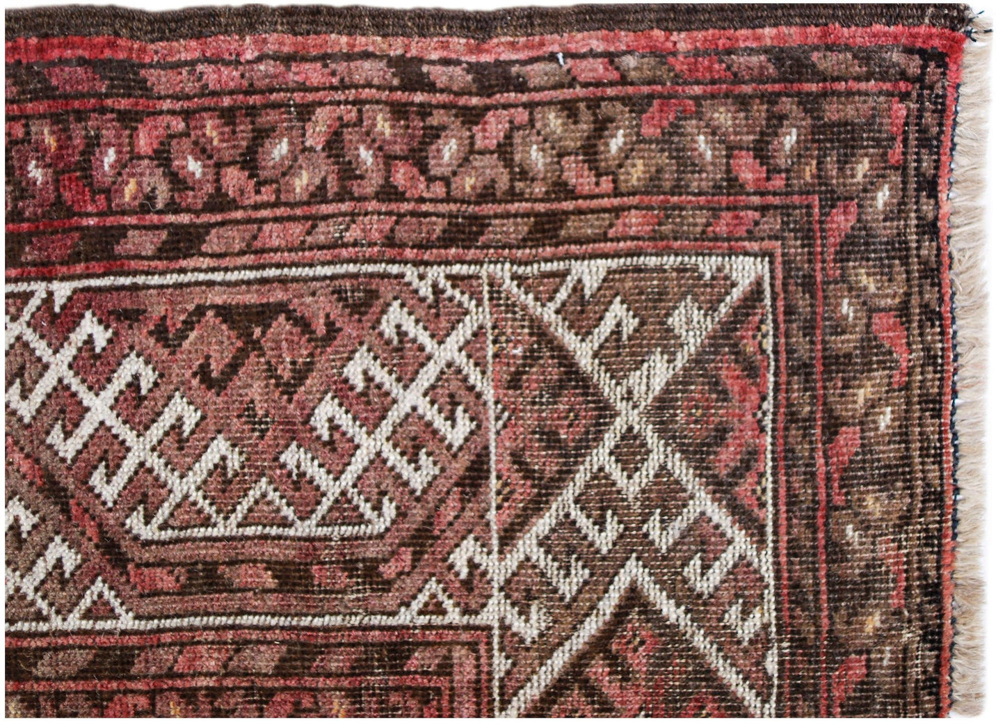 A close-up of an antique Afghan Turkmen rug featuring geometric elephant foot motifs in red and brown.