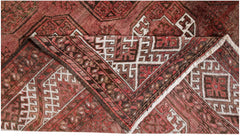An antique Afghan Turkmen rug with geometric elephant foot motifs in shades of red and brown.