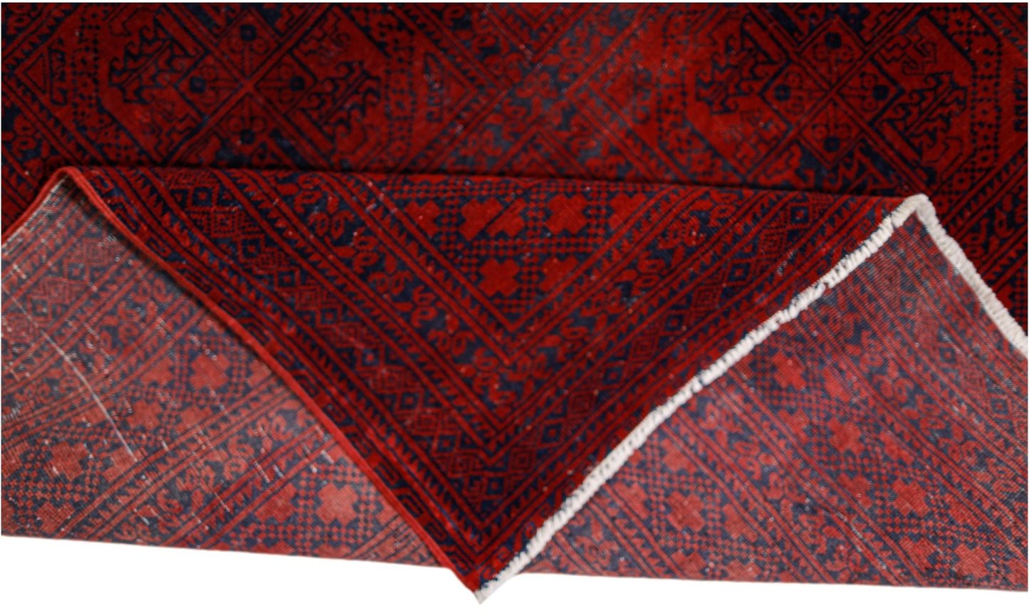 An antique Afghan Turkmen rug with a red field and dark blue elephant foot motifs.