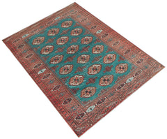 A vintage handwoven Afghan Turkmen rug featuring a teal field with repeating geometric motifs.