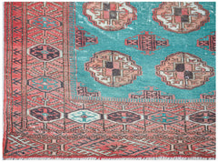 A handwoven vintage Afghan Turkmen rug featuring geometric patterns in teal and red wool.