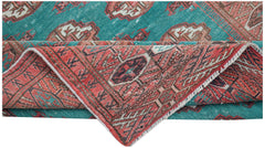 A vintage handwoven Afghan Turkmen rug featuring a teal field with red geometric patterns.
