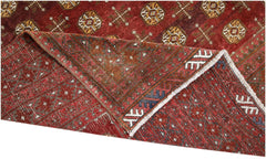 An antique Afghan Turkmen rug featuring geometric medallions in deep red and ivory wool.