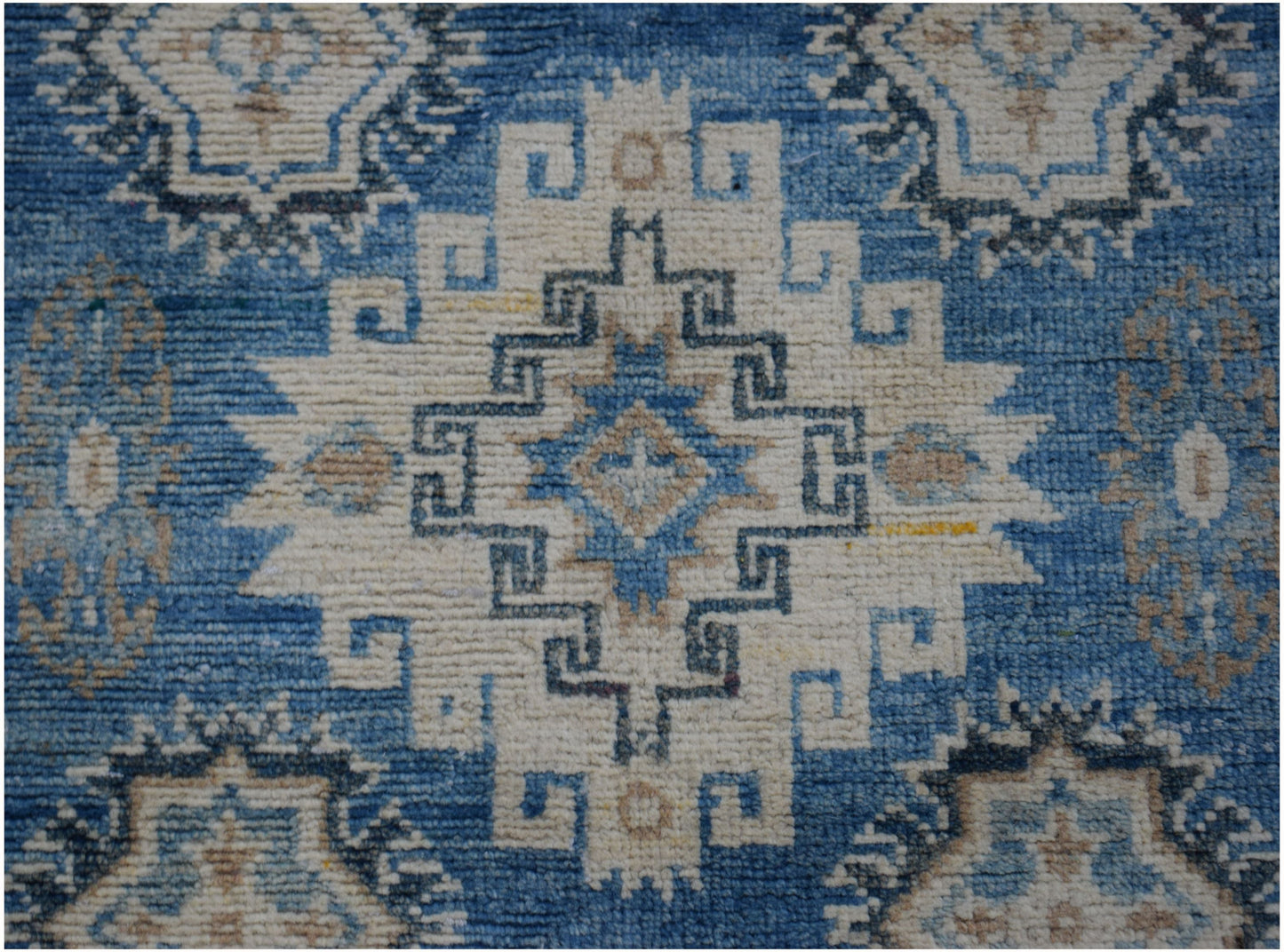 Handmade Afghan Kazakh runner rug featuring a geometric medallion pattern in blue and beige.