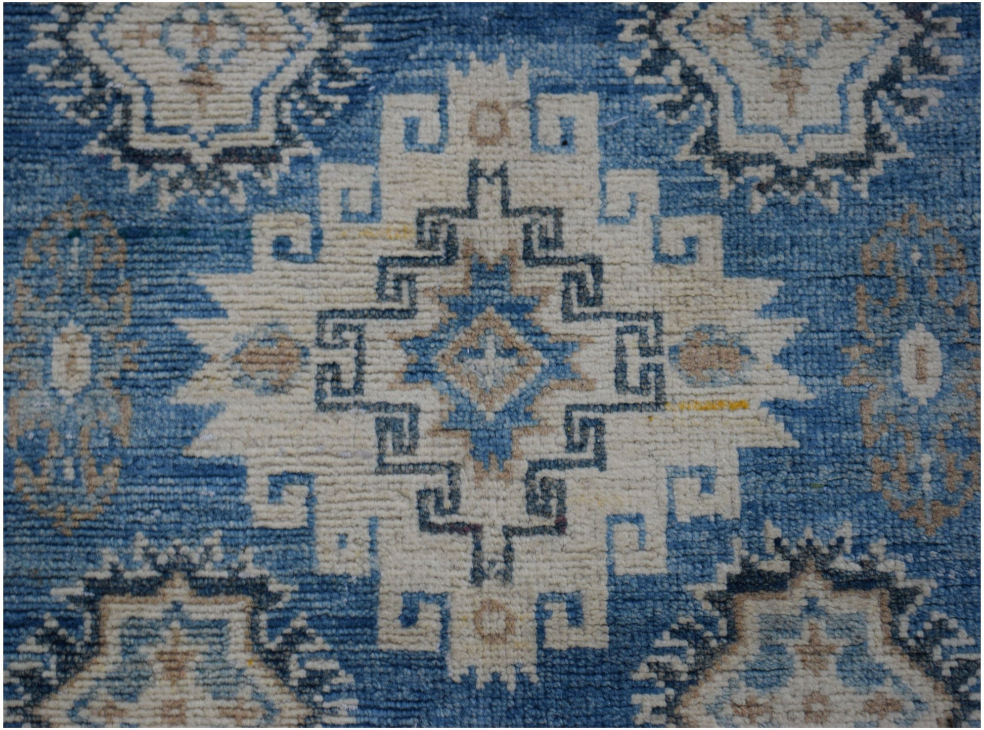 Handmade Afghan Kazakh runner rug featuring a geometric medallion pattern in blue and beige.