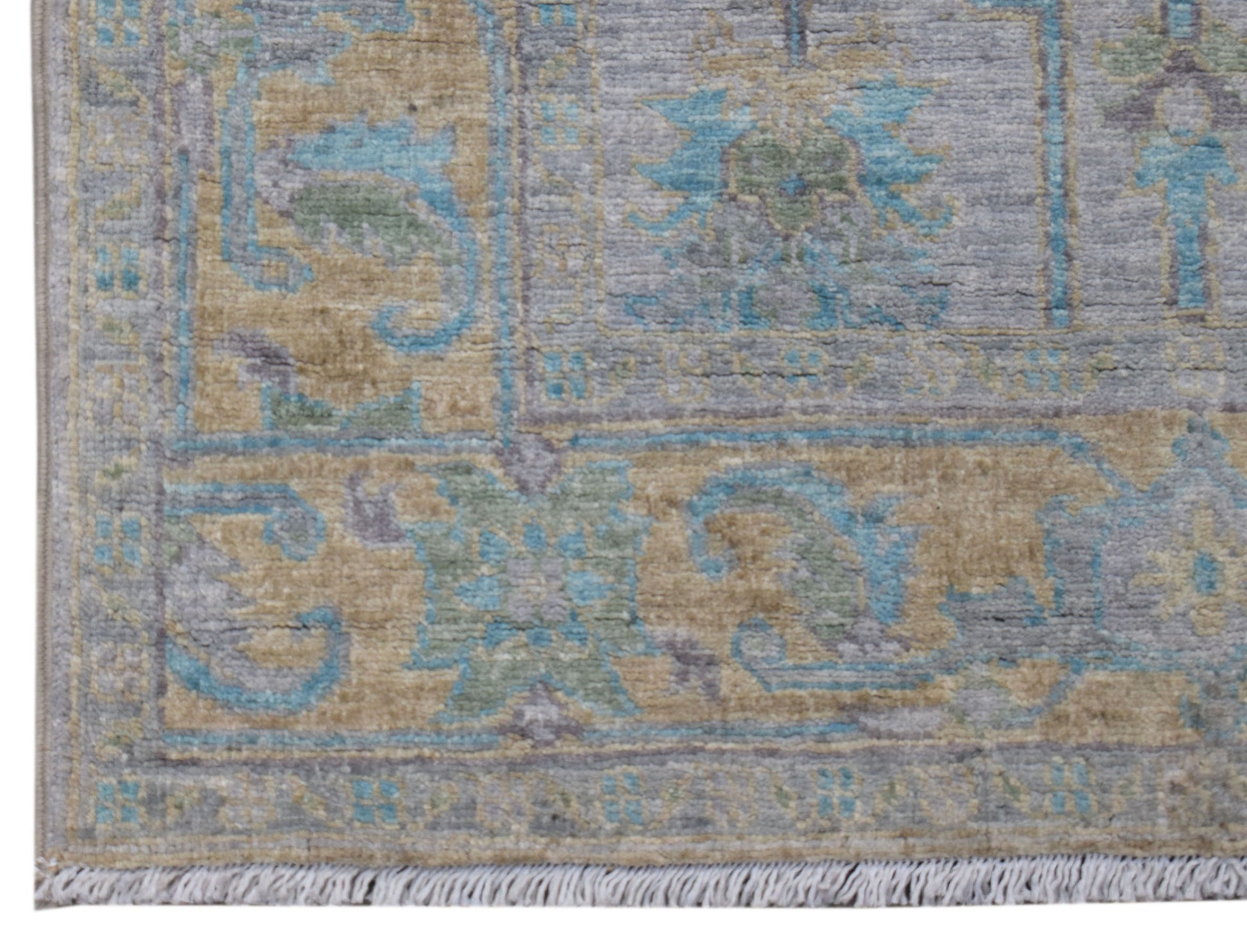 A transitional Oushak runner featuring a floral pattern in muted blue, tan, and grey tones.