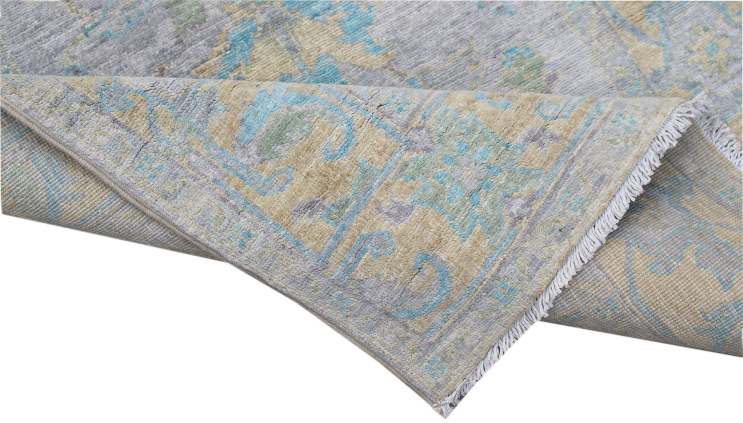 A handwoven transitional Oushak runner featuring a floral pattern in blue, grey, and beige tones.