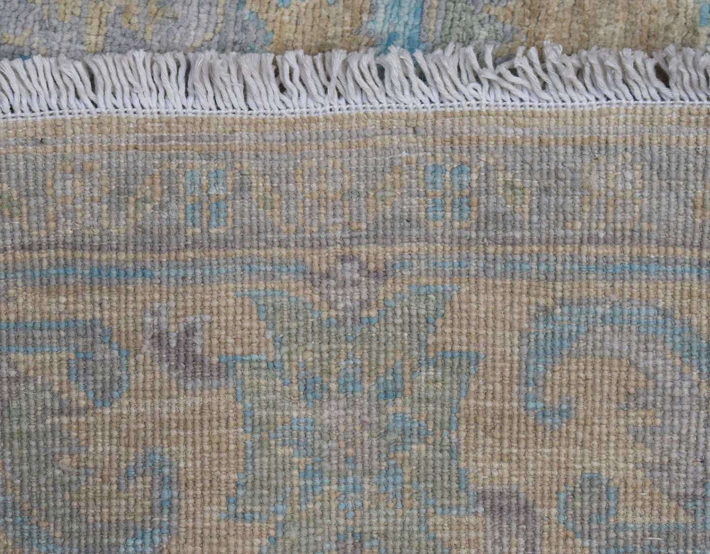 A close-up of a handwoven transitional Oushak runner featuring a floral pattern in muted tones.