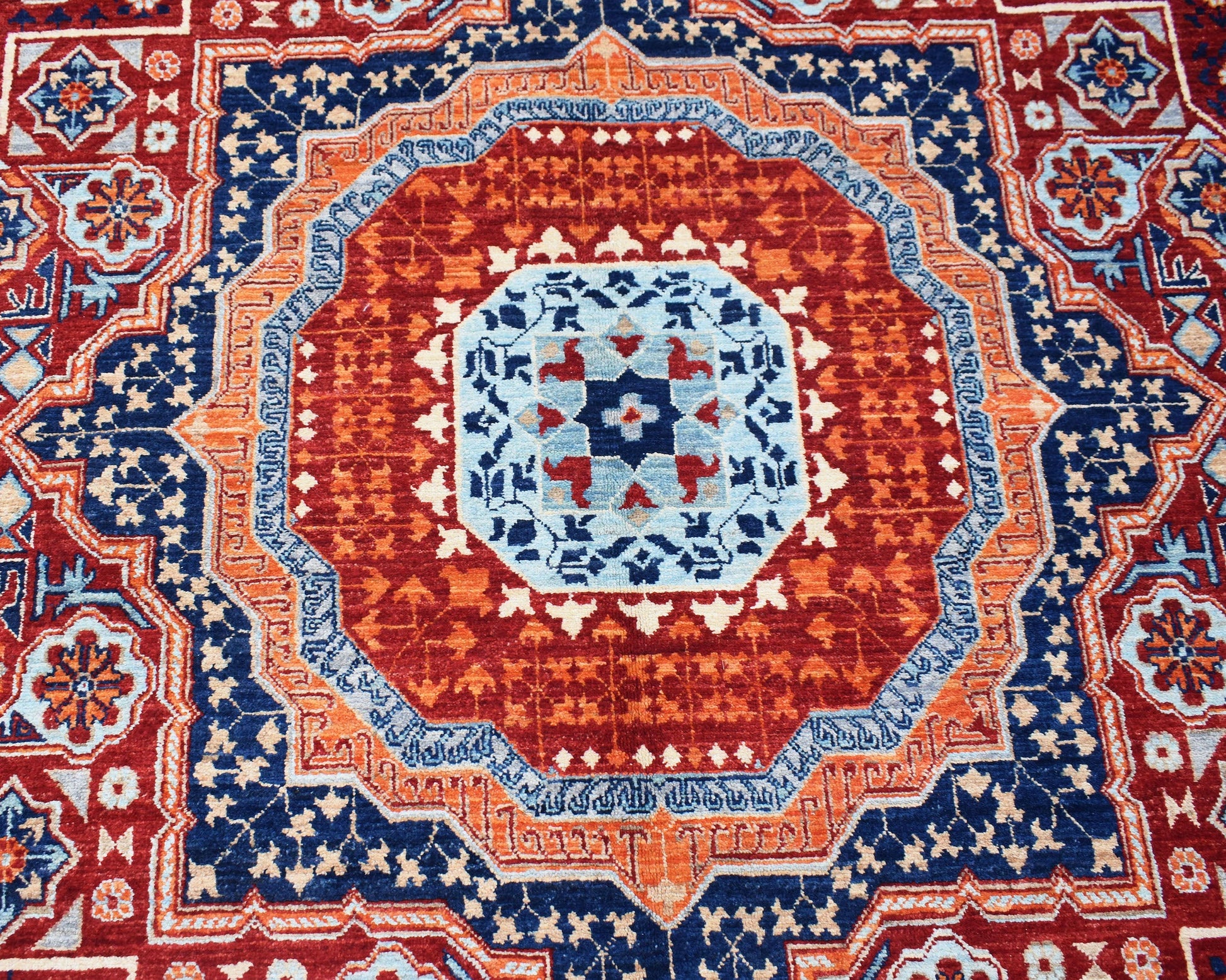 Handwoven Afghan Chobi rug featuring a detailed Mamluk medallion in red, blue, and orange tones.
