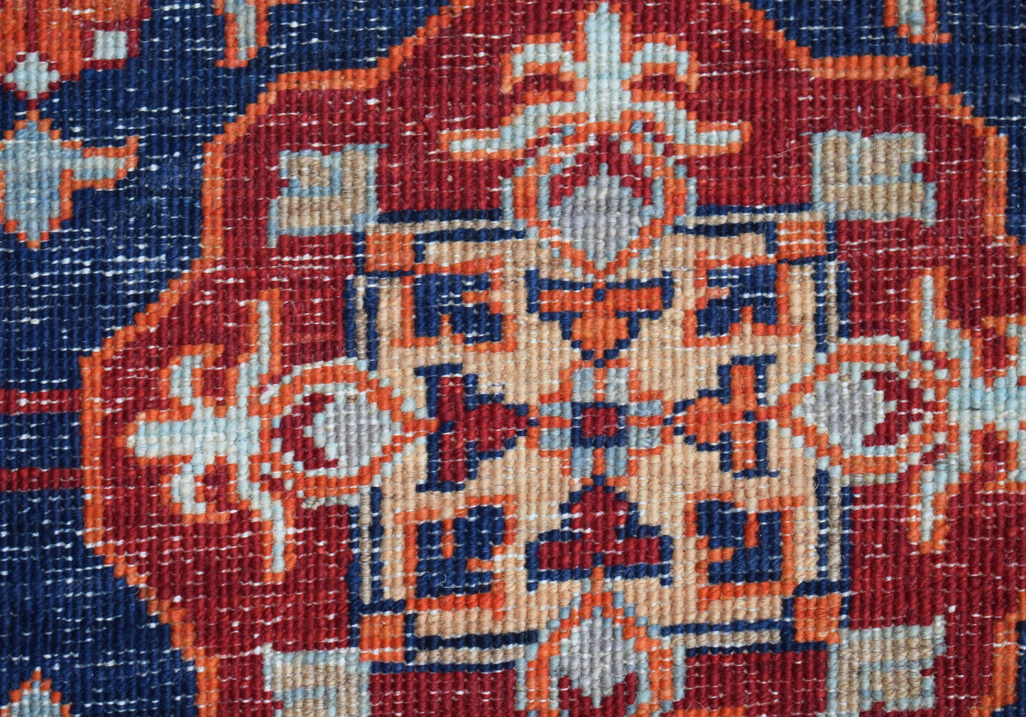 A close-up of a handwoven Afghan Chobi rug featuring a detailed geometric Mamluk medallion pattern.