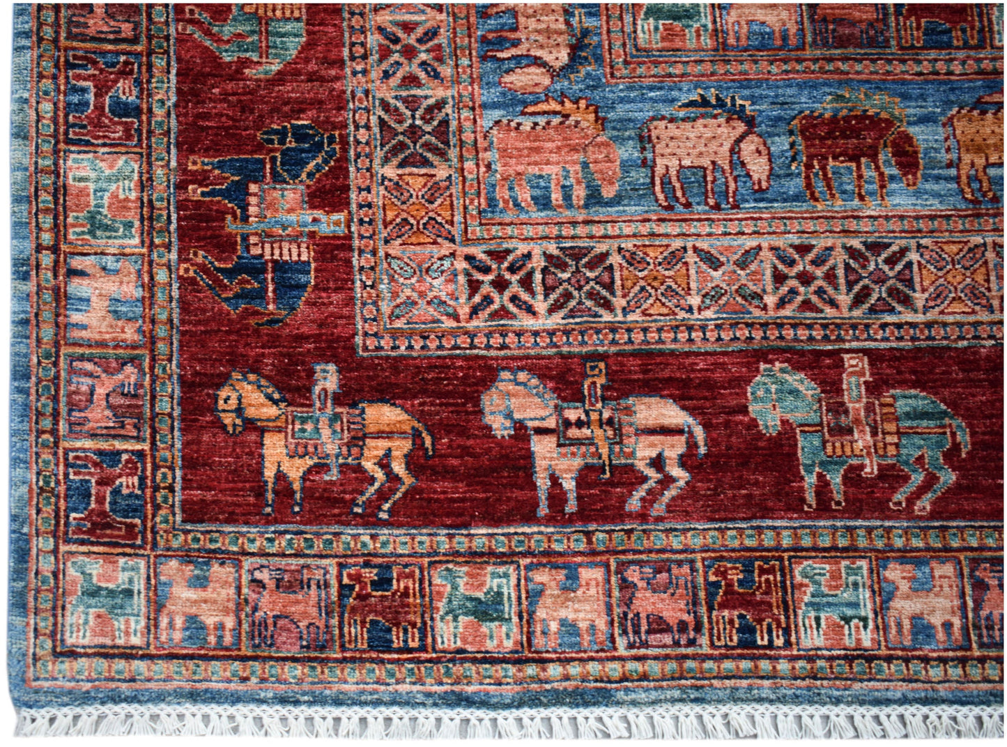Handwoven Afghan Chobi rug featuring traditional equestrian and animal motifs in a red and blue palette.