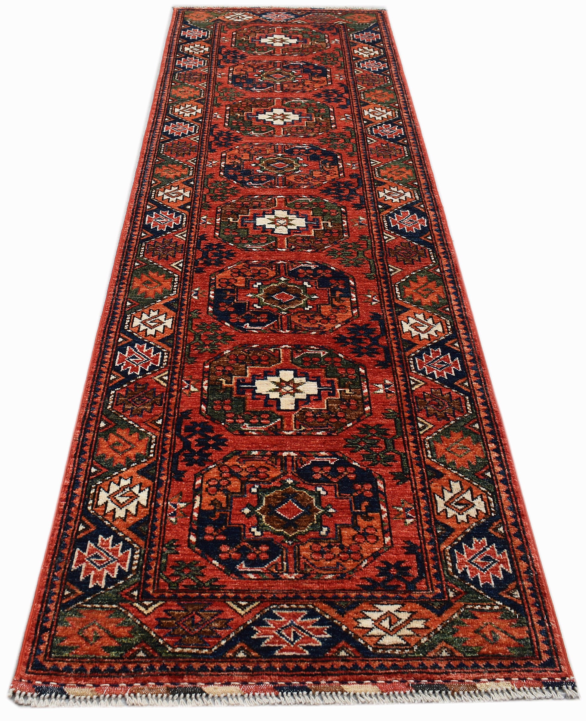 A handmade Afghan Chobi runner rug featuring traditional geometric patterns in red, blue, and cream.