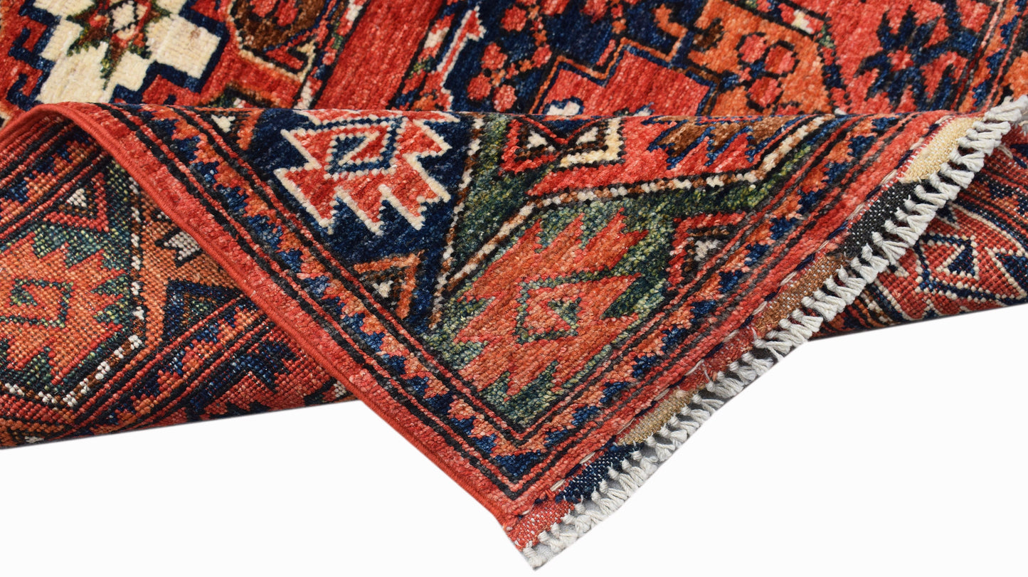 A handwoven Afghan Chobi runner featuring traditional geometric patterns in red, blue, and green.