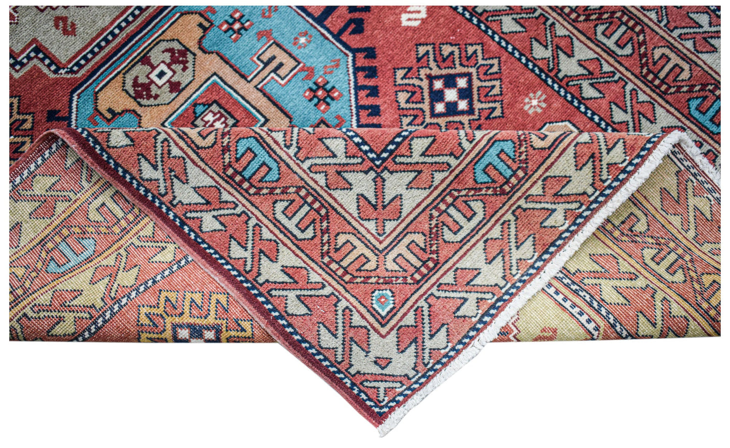 A handwoven vintage Caucasian wool rug featuring geometric patterns in red, blue, and beige.