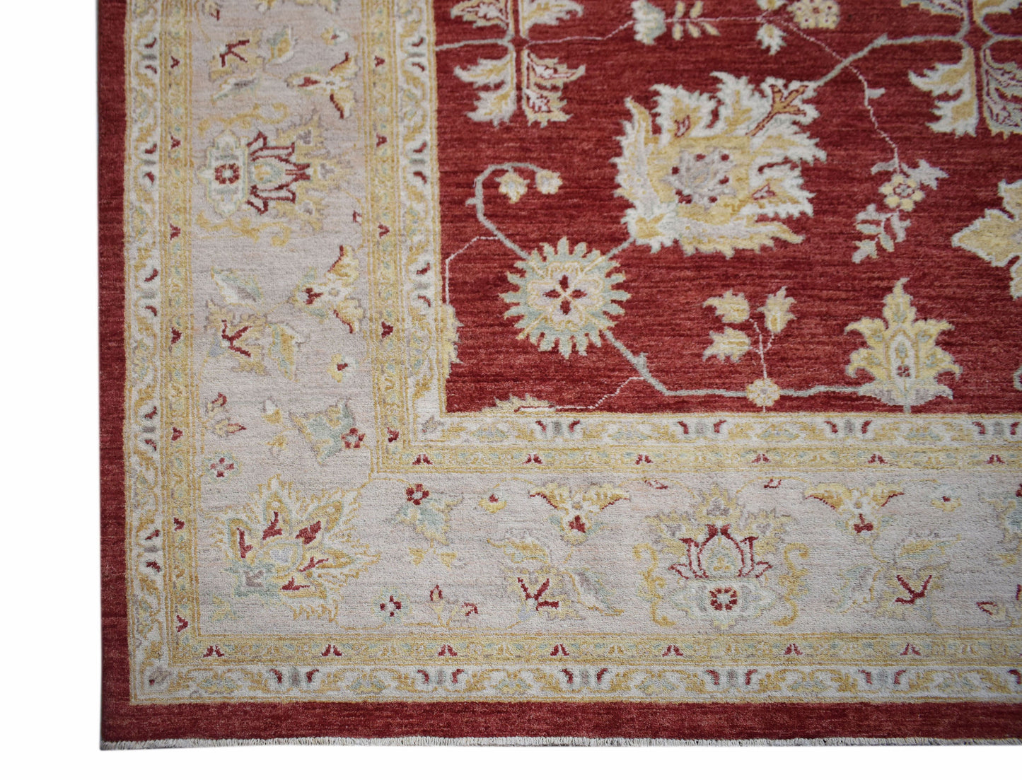 A handmade Afghan Chobi rug featuring a red field with floral patterns and a cream border.