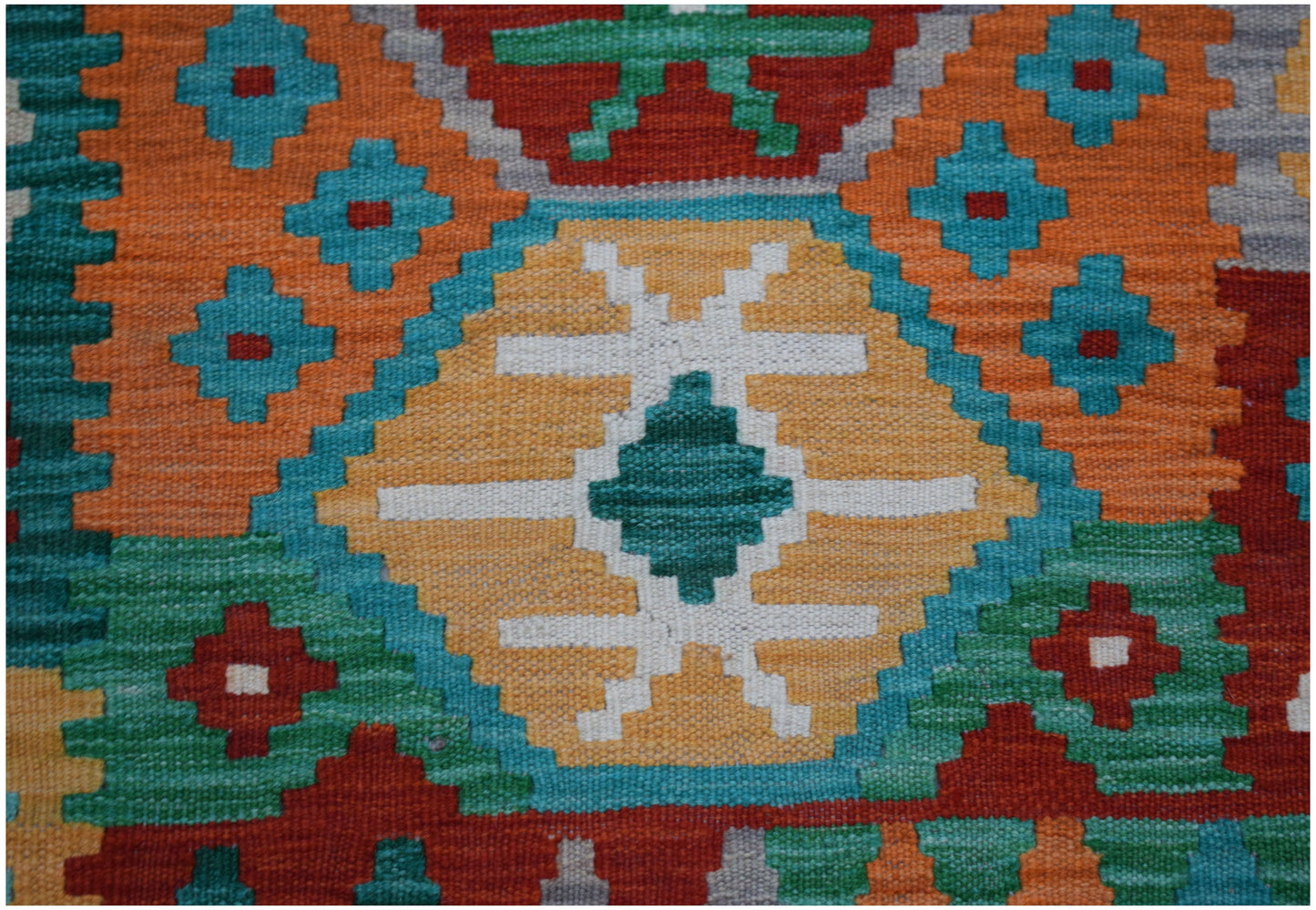 Handwoven Afghan Maimana kilim runner featuring a vibrant geometric pattern in wool.