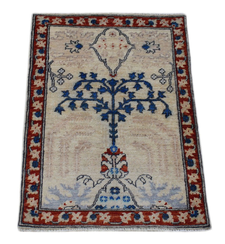 A handmade Afghan Chobi rug featuring a central blue tree motif on a cream field with a red border.