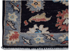 A handmade Afghan Chobi rug featuring a floral pattern in muted tones on a dark background.