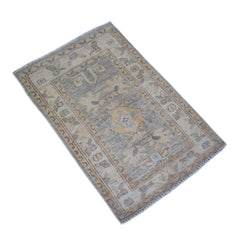 A handmade mini Afghan Chobi rug featuring a traditional geometric pattern in muted earth tones.