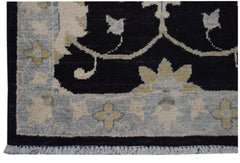 A handmade Afghan Chobi rug featuring a black field with floral patterns and a light grey border.