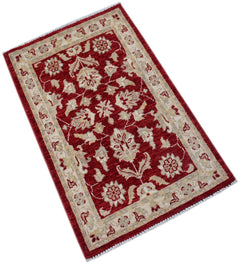 A handmade Afghan Chobi rug featuring a floral pattern in cream on a deep red background.