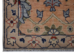 A handmade Afghan Chobi rug featuring a floral pattern in shades of peach, blue, and green.