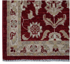 A handmade Afghan Chobi rug featuring a traditional floral pattern in red and beige tones.