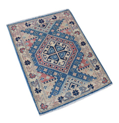 A handmade mini Afghan Kazakh rug featuring a geometric pattern in blue, pink, and cream wool.