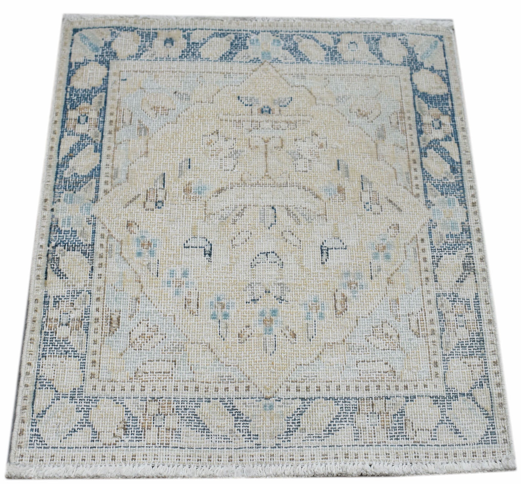 A mini vintage Persian Kerman rug featuring a central medallion in soft blue and beige tones.