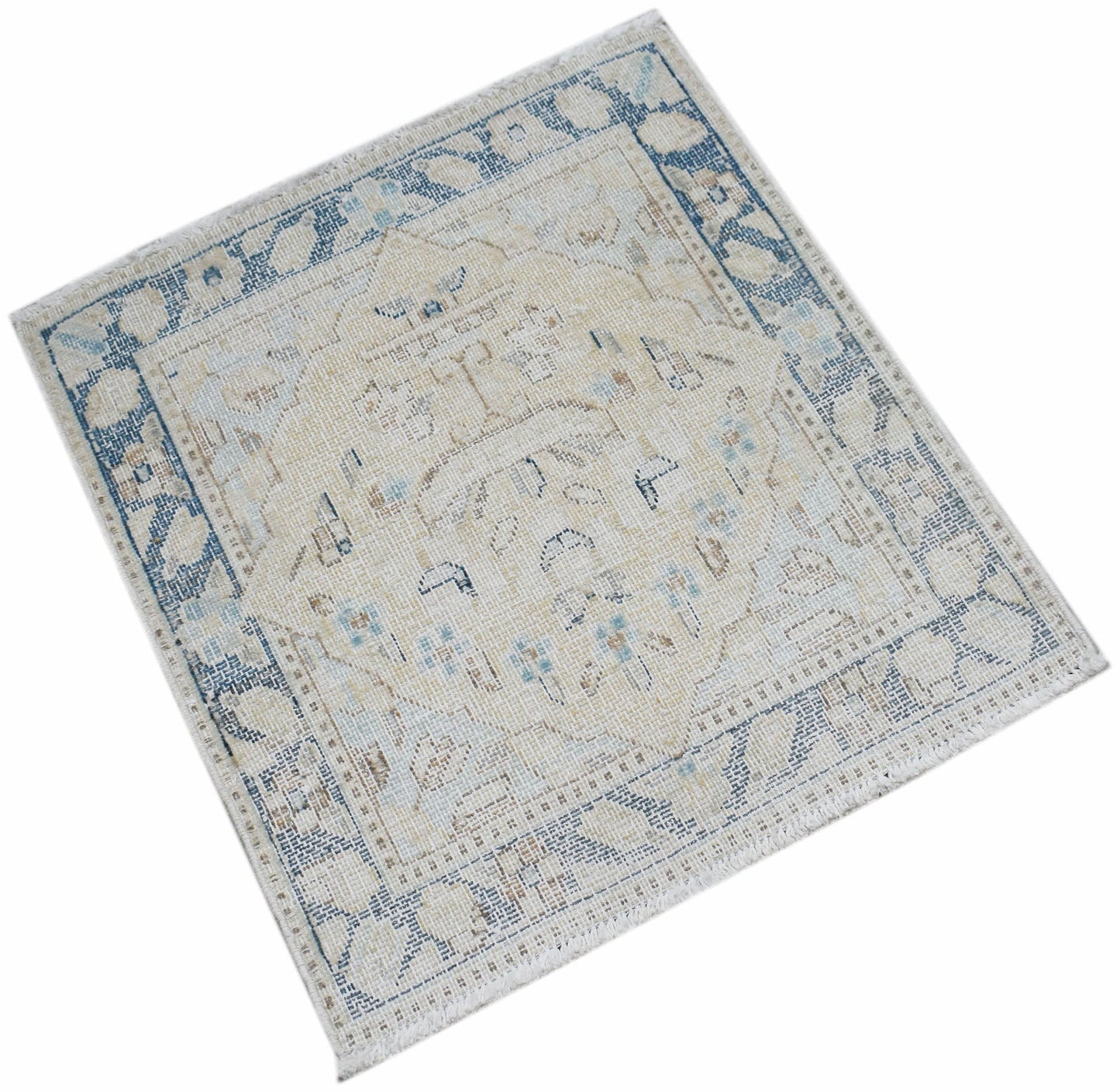 A mini vintage Persian Kerman rug featuring a central medallion and floral motifs in blue and beige.