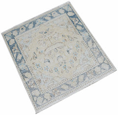 A mini vintage Persian Kerman rug featuring a central medallion and floral motifs in blue and beige.
