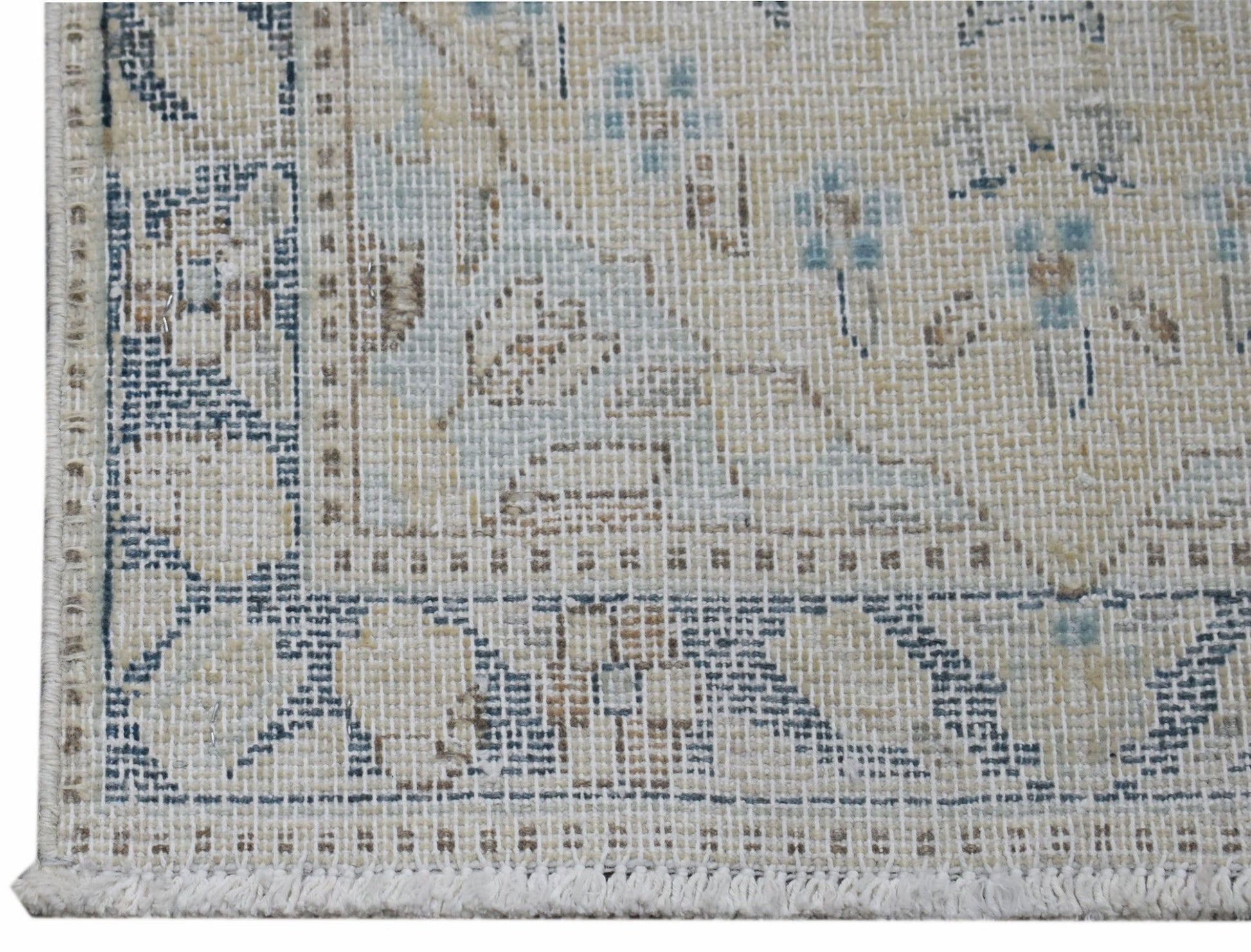 A close-up of a vintage Persian Kerman rug featuring intricate floral patterns in muted tones.