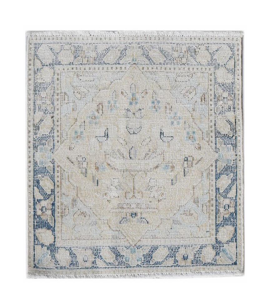 A mini vintage Persian Kerman rug featuring a central medallion in soft blue and beige tones.