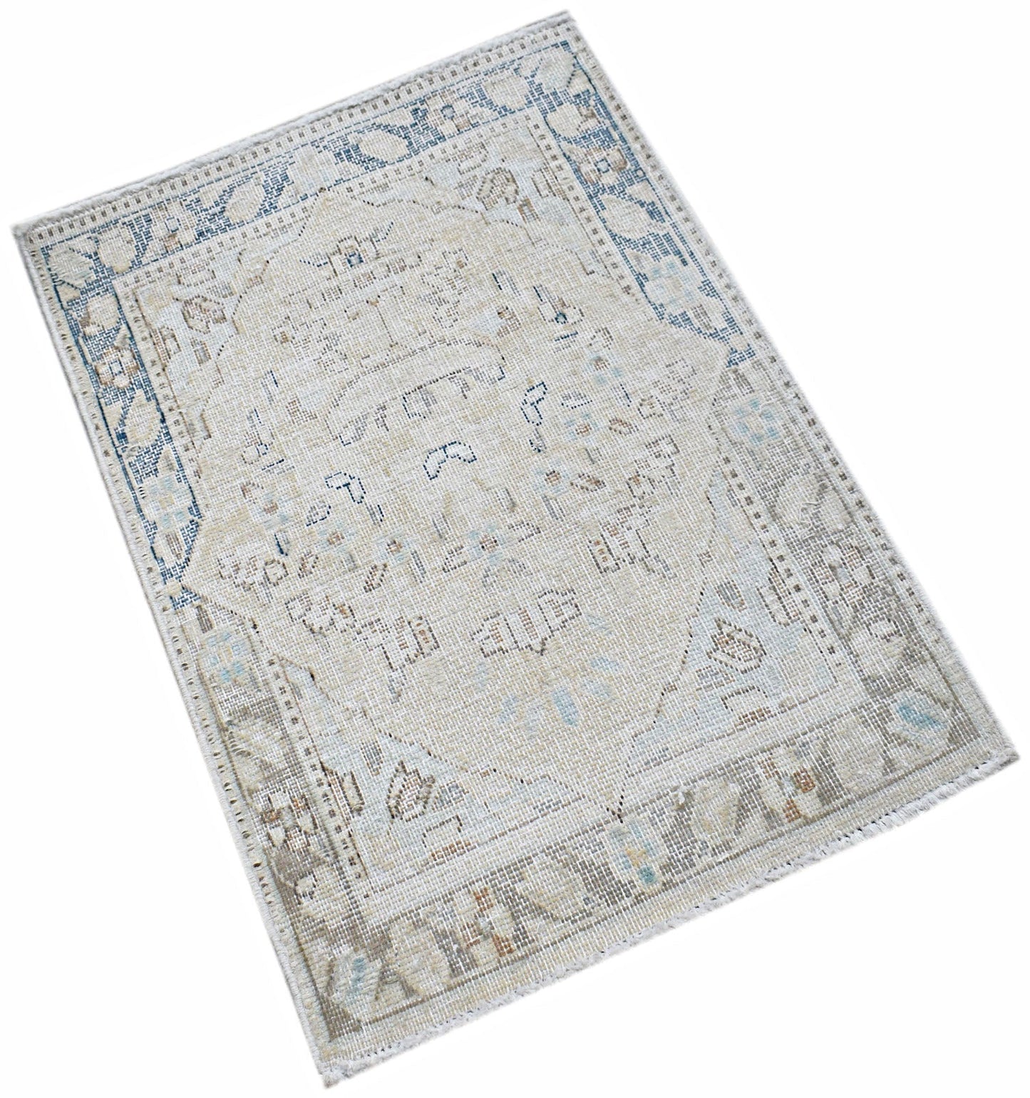 A mini vintage Persian Kerman rug featuring a central medallion and floral motifs in muted tones.