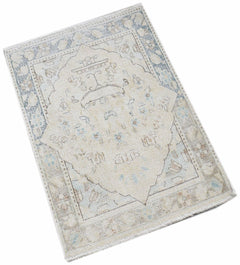 A mini vintage Persian Kerman rug featuring a central medallion in soft blue and beige tones.