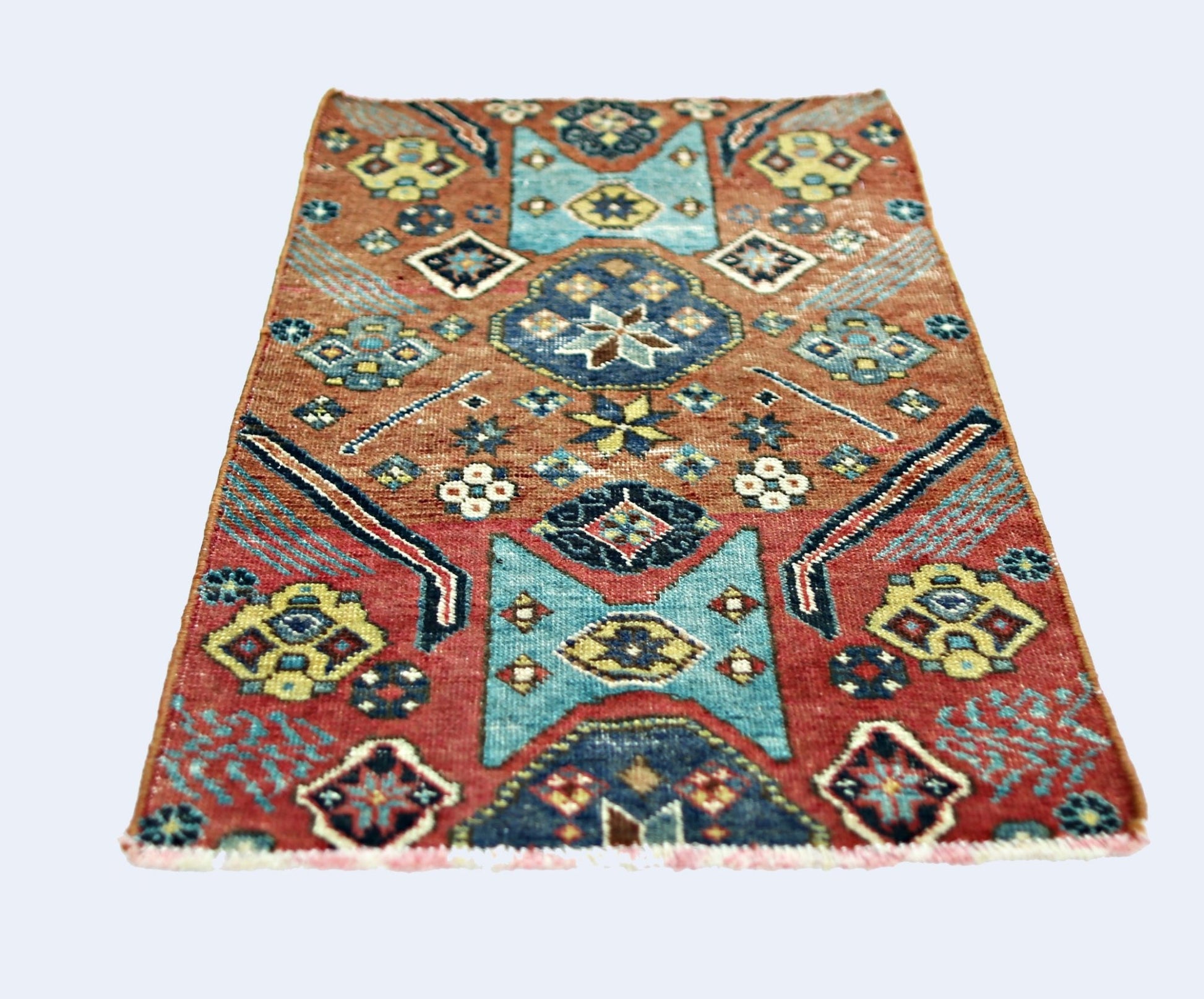 A rectangular vintage Persian rug featuring geometric patterns in red, blue, and yellow tones.