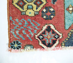 A close-up of a handmade vintage Persian rug featuring intricate geometric patterns in red and blue.