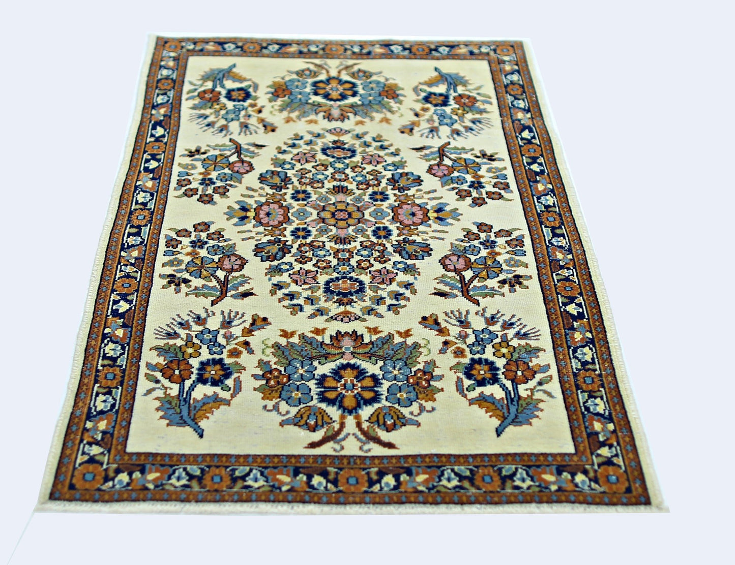 A vintage Persian Sarouk rug featuring a central floral medallion on a cream background.
