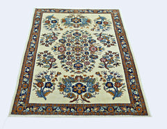A vintage Persian Sarouk rug featuring a central floral medallion on a cream background.