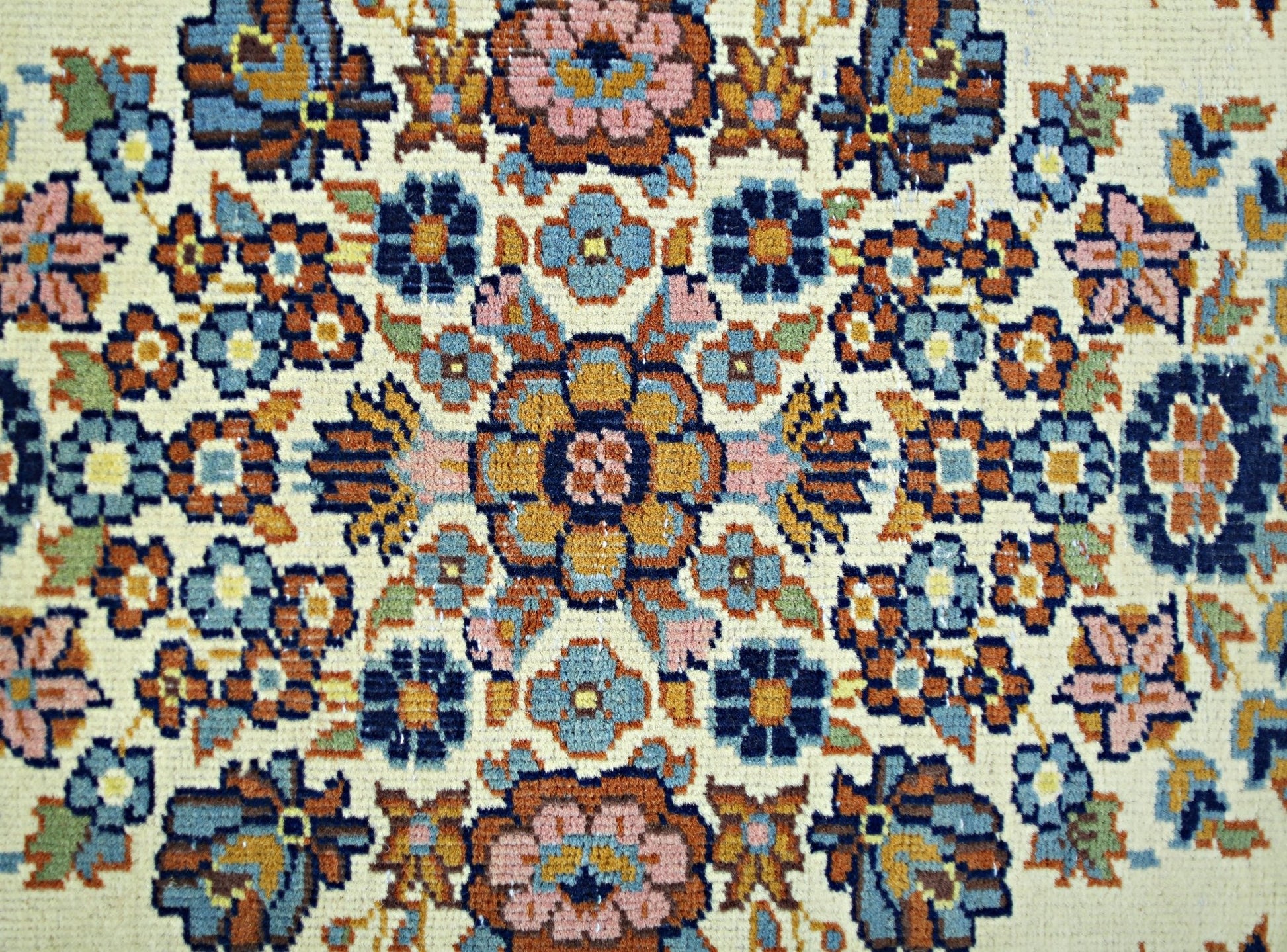 A vintage Persian Sarouk rug featuring a detailed floral medallion pattern in blue and orange.